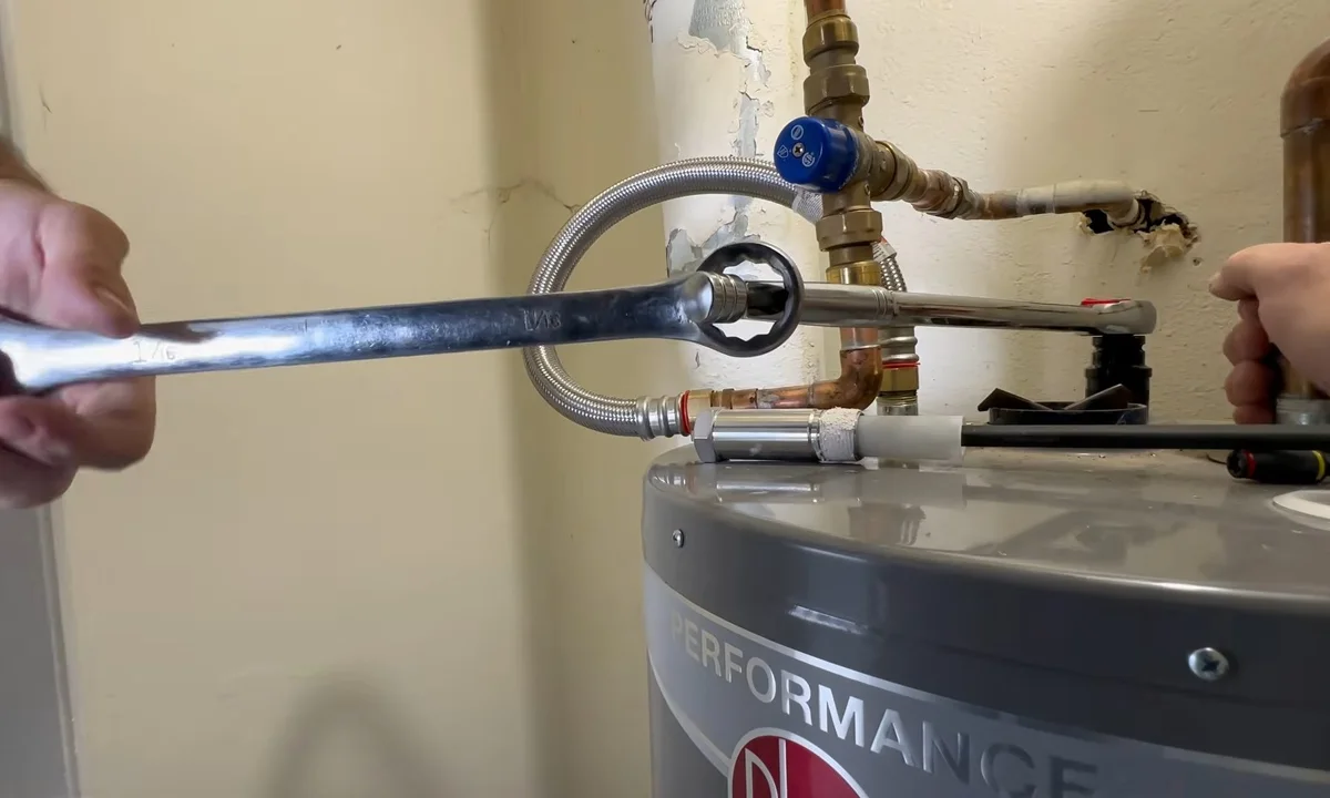 Anode rod being inspected above a water heater illustrating your water heater's anode rod
