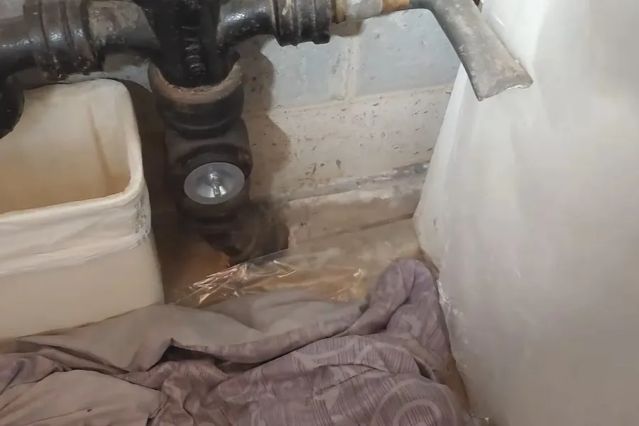 Basement trap and drain pipe near a wall during a plumbing service call in Phoenix, AZ
