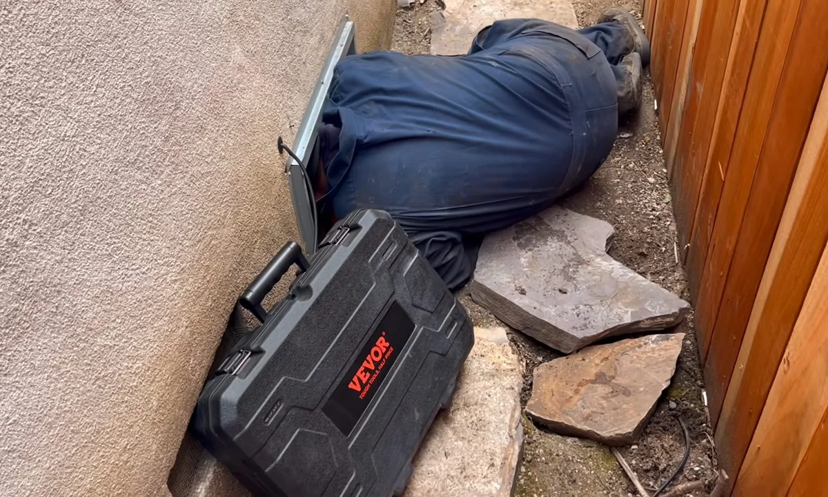 Plumber checking leak equipment in a crawl space during a plumbing service call in Mesa, AZ