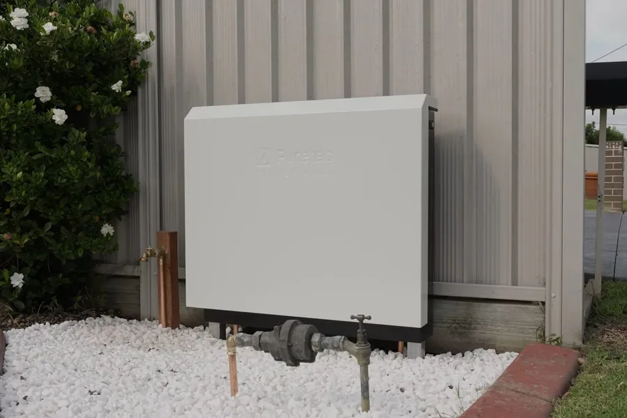 Closed home filtration cabinet beside landscaping for water filtration installation in Fountain Hills