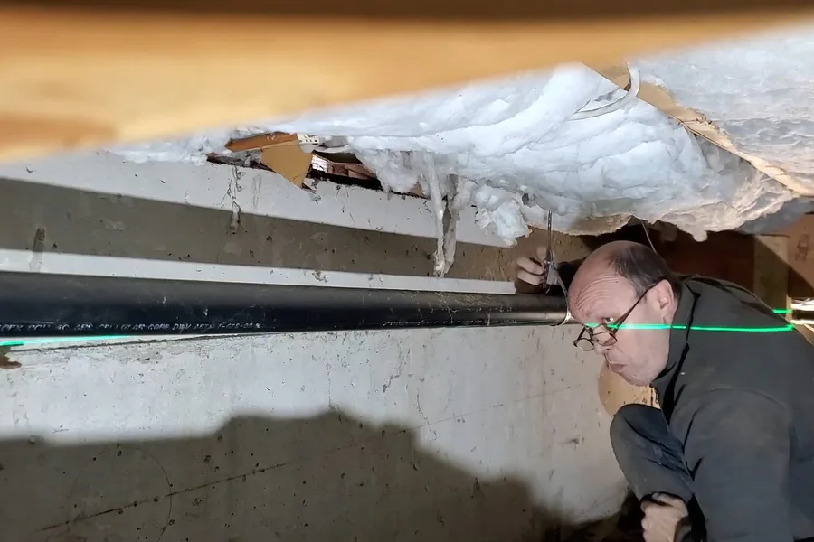 Crawl space drain line below insulation during a plumbing service call in SunRidge Canyon, Fountain Hills, AZ