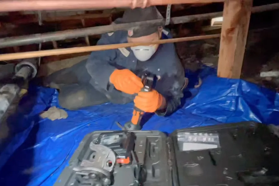 Plumber drilling beneath a house on a tarp for 24/7 emergency plumber in Fountain Hills