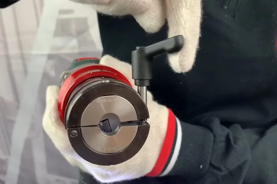 Gloved hand holding a red pipe deburring tool during a plumbing service call in Carefree, AZ