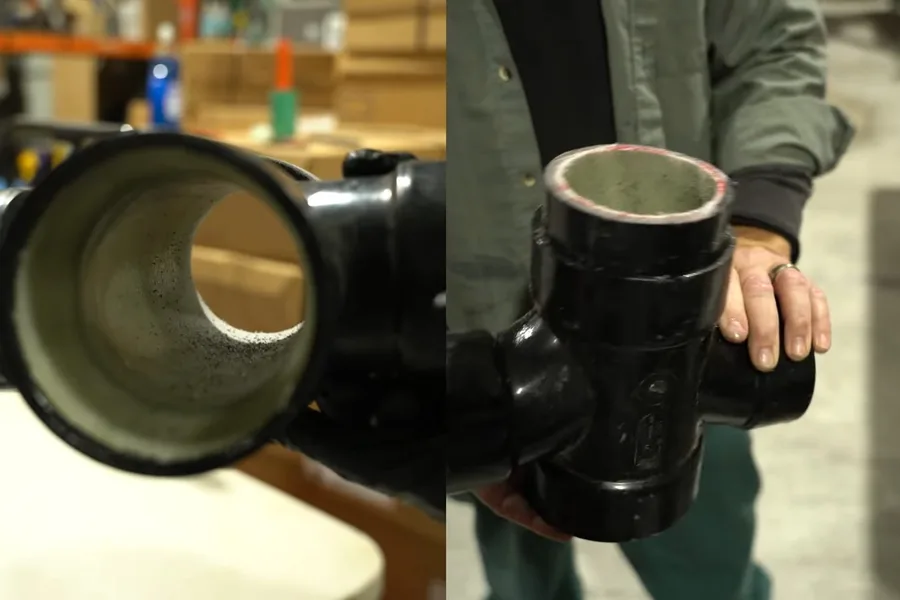 Large black sewer pipe fitting held for inspection for hydro jetting in Fountain Hills