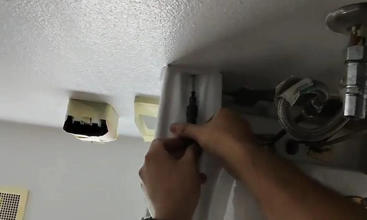 Plumber opening ceiling access above a bathroom during a plumbing service call in Chandler, AZ