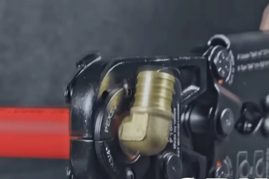 Pex crimping tool clamped on red pipe illustrating repipe or keep repairing? a fountain hills homeowner's decision guide
