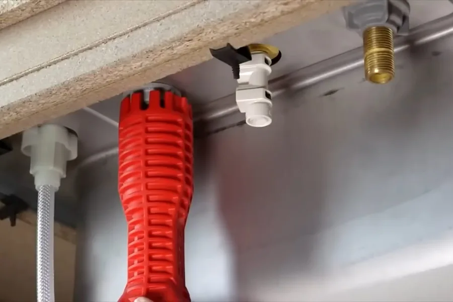 Red corrugated drain hose below a countertop during a plumbing service call in Carefree, AZ