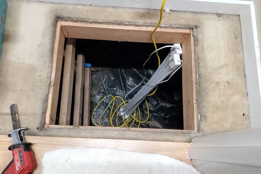 Red sewer camera locator under a crawl space pipe during a plumbing service call in Scottsdale, AZ