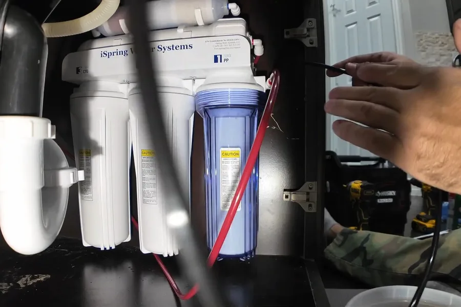 Reverse osmosis filters and tubing mounted under a sink illustrating softener vs. reverse osmosis vs. whole-house filtration