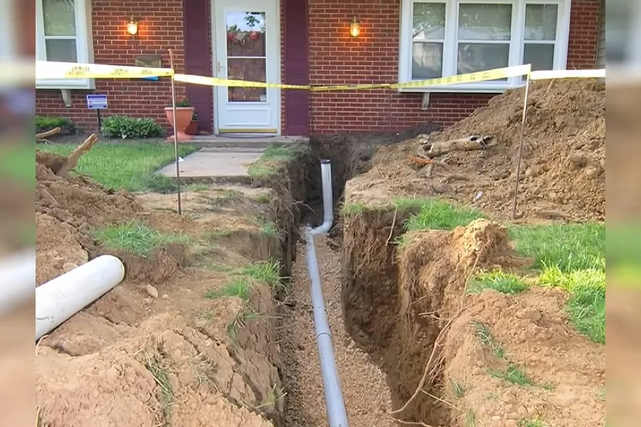 Sewer replacement trench beside a home foundation for sewer line replacement in Fountain Hills