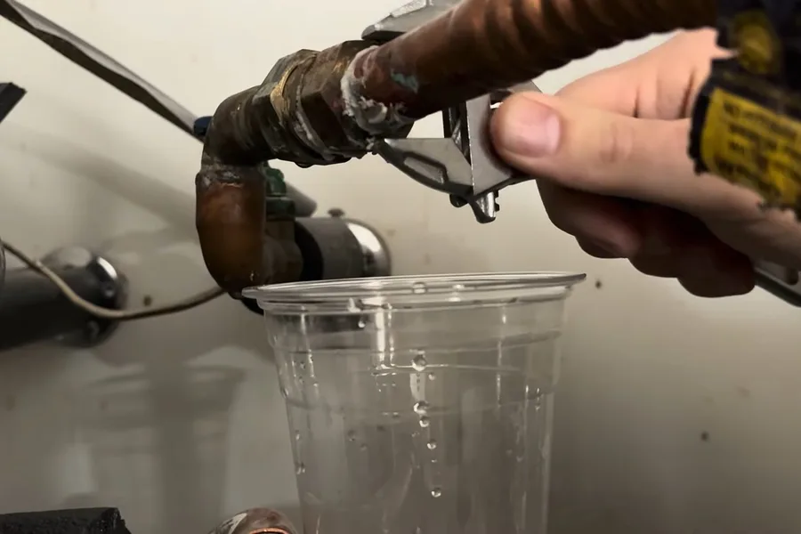 Plumber tightening a water heater inlet hose for hose bib & outdoor faucet repair in Fountain Hills