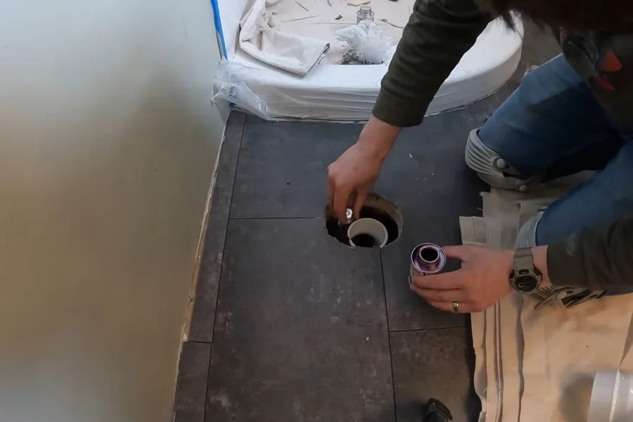 Toilet drain flange set in tile floor during a plumbing service call in Mesa, AZ