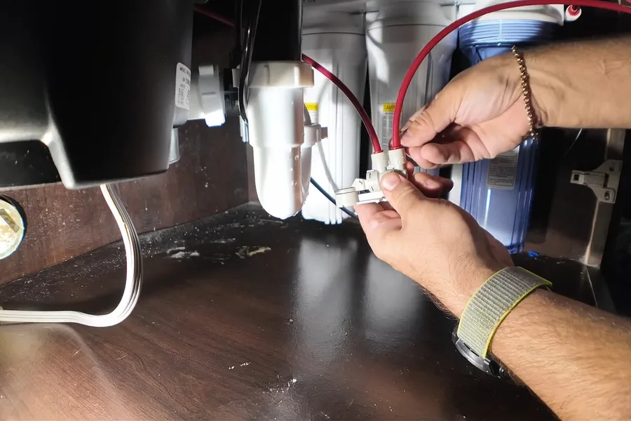 Plumber wiring a garbage disposal under a sink for garbage disposal repair & installation in Fountain Hills